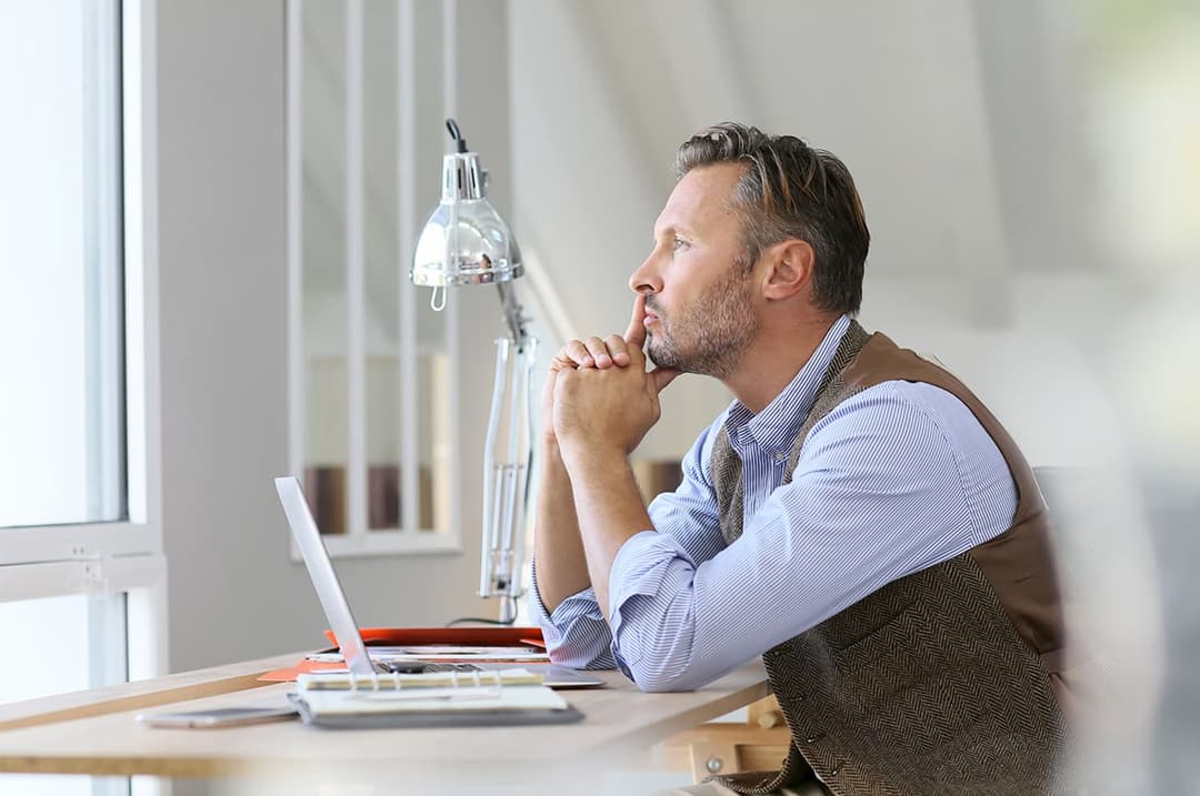 Man at desk thinking and researching